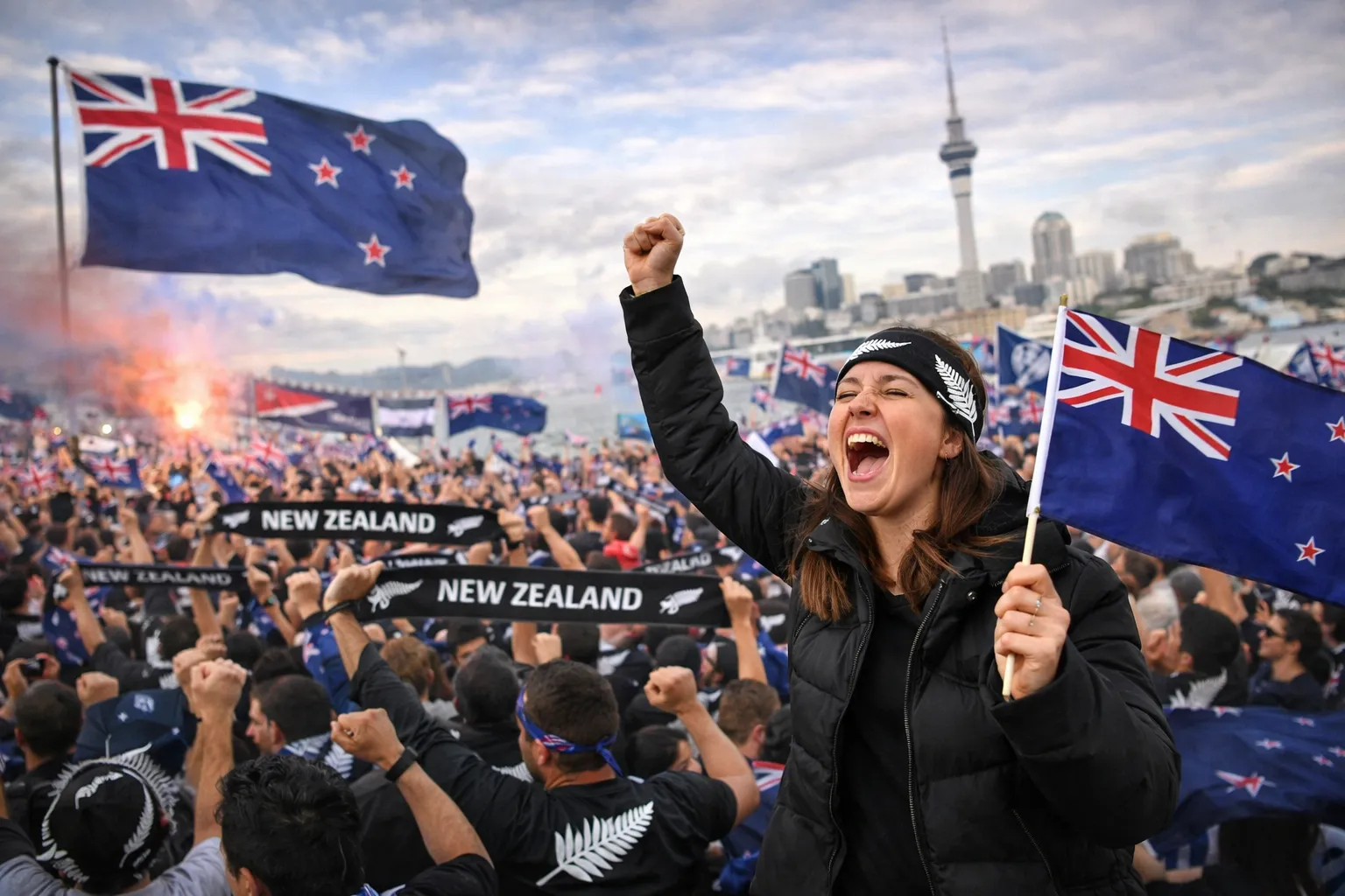 Supporters met Nieuw-Zeeland vlaggen en sjaals juichen op sportevenement
