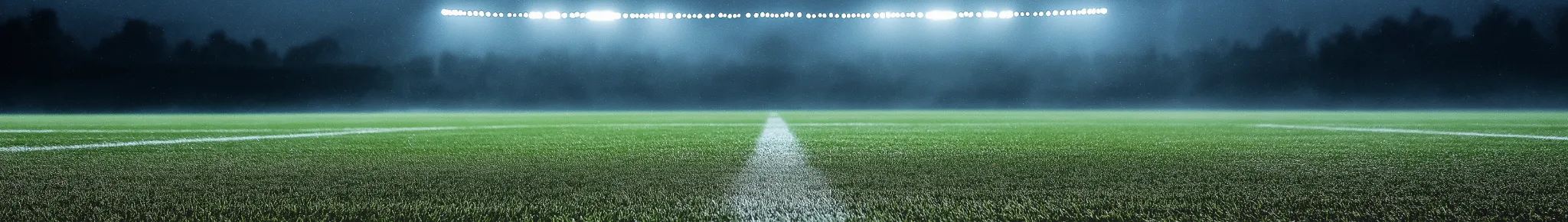 Lage hoek van een voetbalveld met stadionlichten en mistige sfeer.