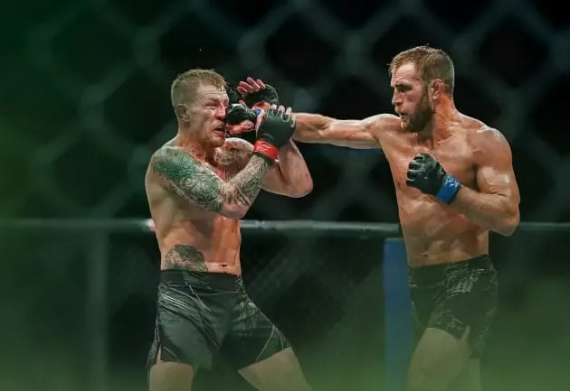 Twee MMA vechters in de PFL, de ene vechter incasseert een stoot van de ander.