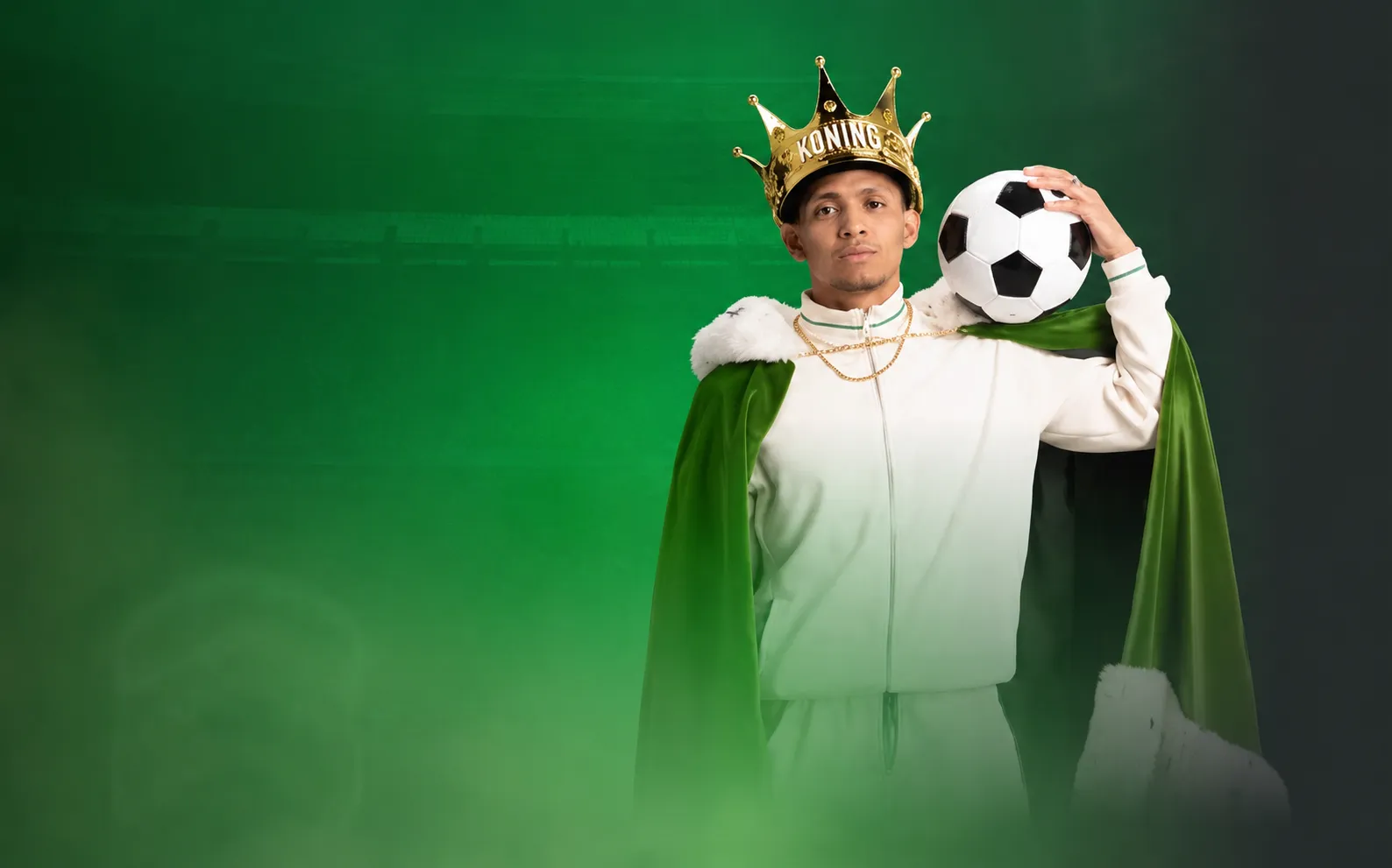 Man met gouden kroon en groene mantel houdt voetbal vast als koning van het voetbal