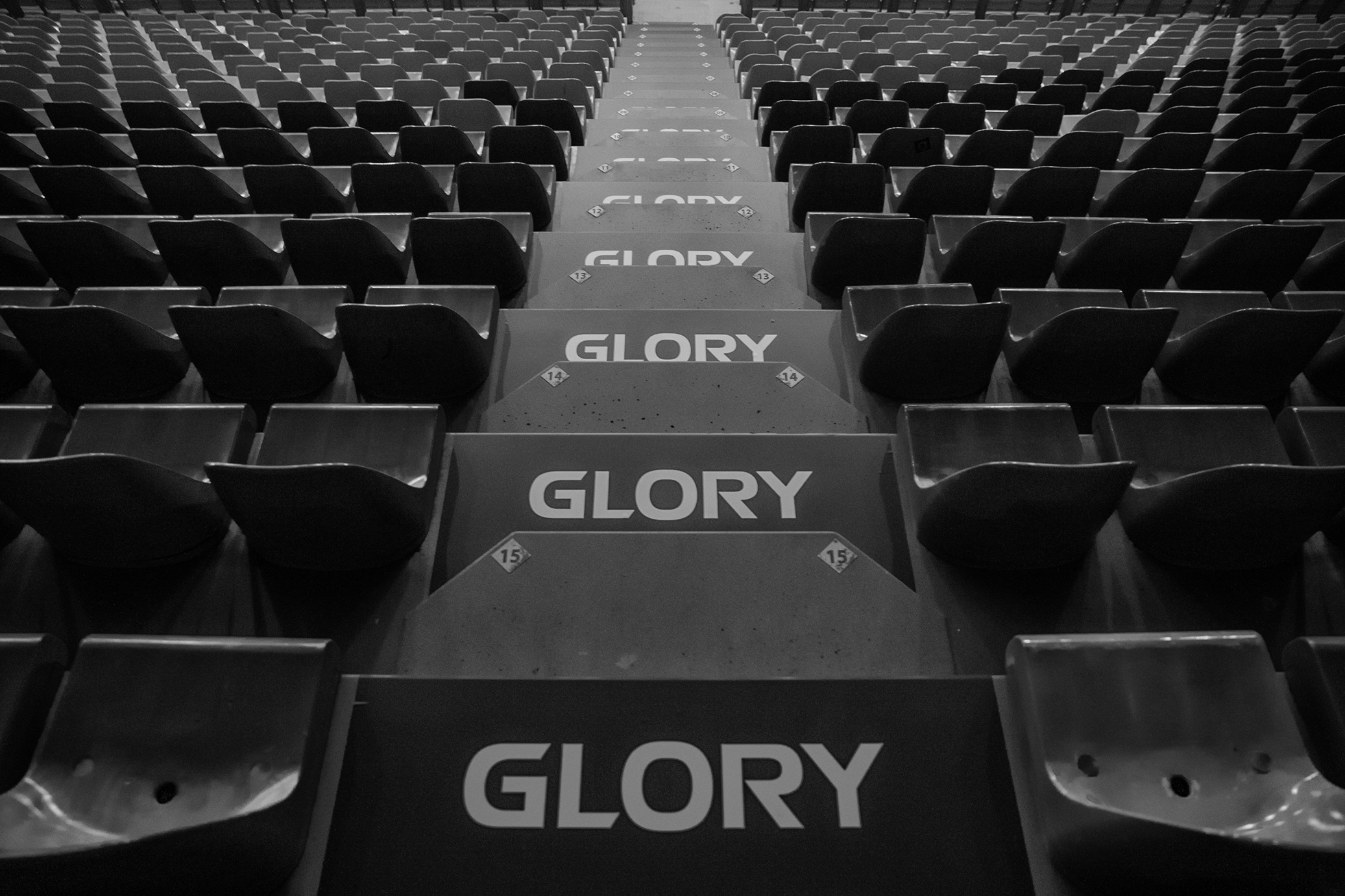 Stoeltjes en trappen in een stadion met op de trappen de letters 'GLORY'