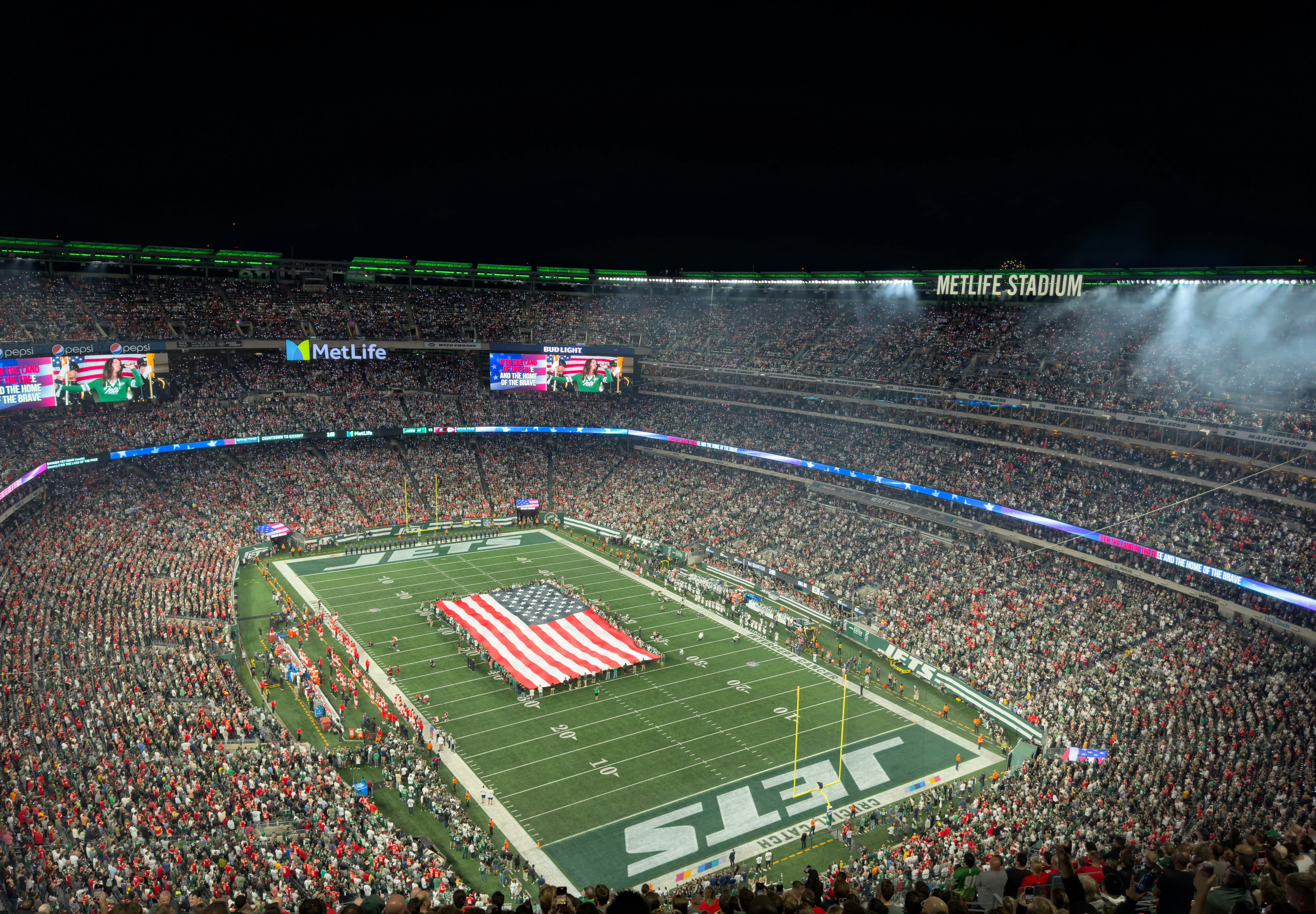 Vol stadion bij American football wedstrijd in MetLife Stadium met groot Amerikaans vlag