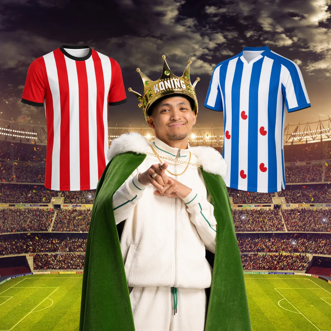 Man met koningskroon en cape tussen rood-wit gestreept en blauw-wit gestreept voetbalshirt in stadion