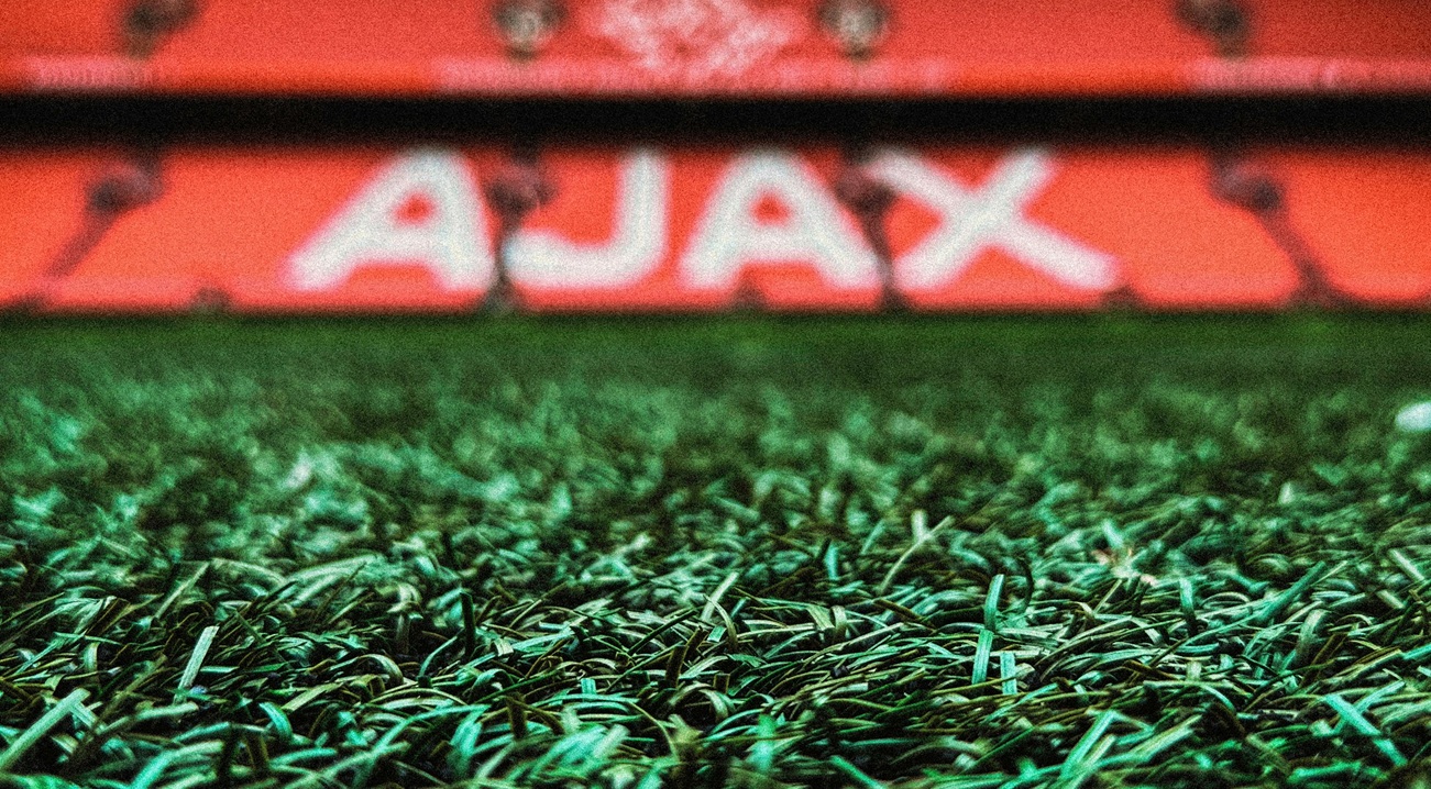 Close-up gras met AJAX bord