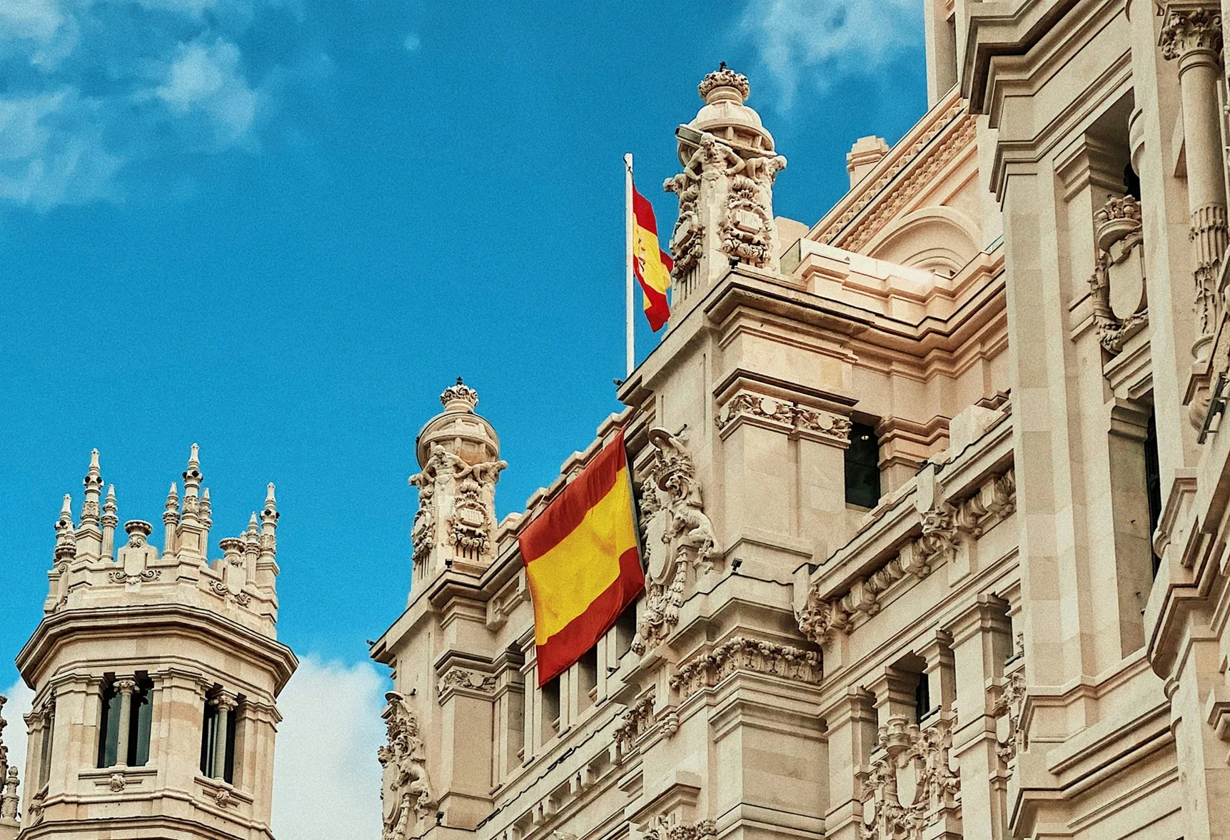 Historisch gebouw met Spaanse vlag onder blauwe lucht