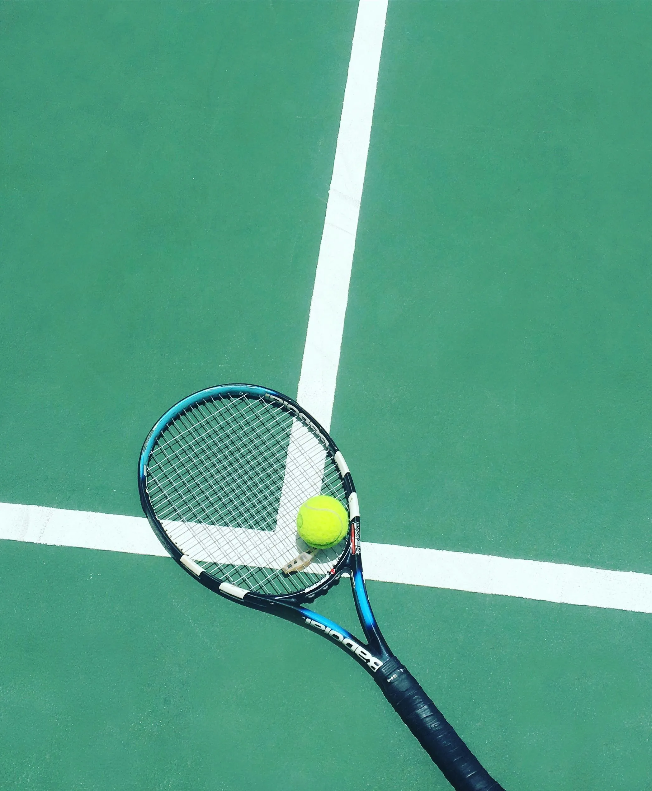 Tennisracket en bal op tennisbaan
