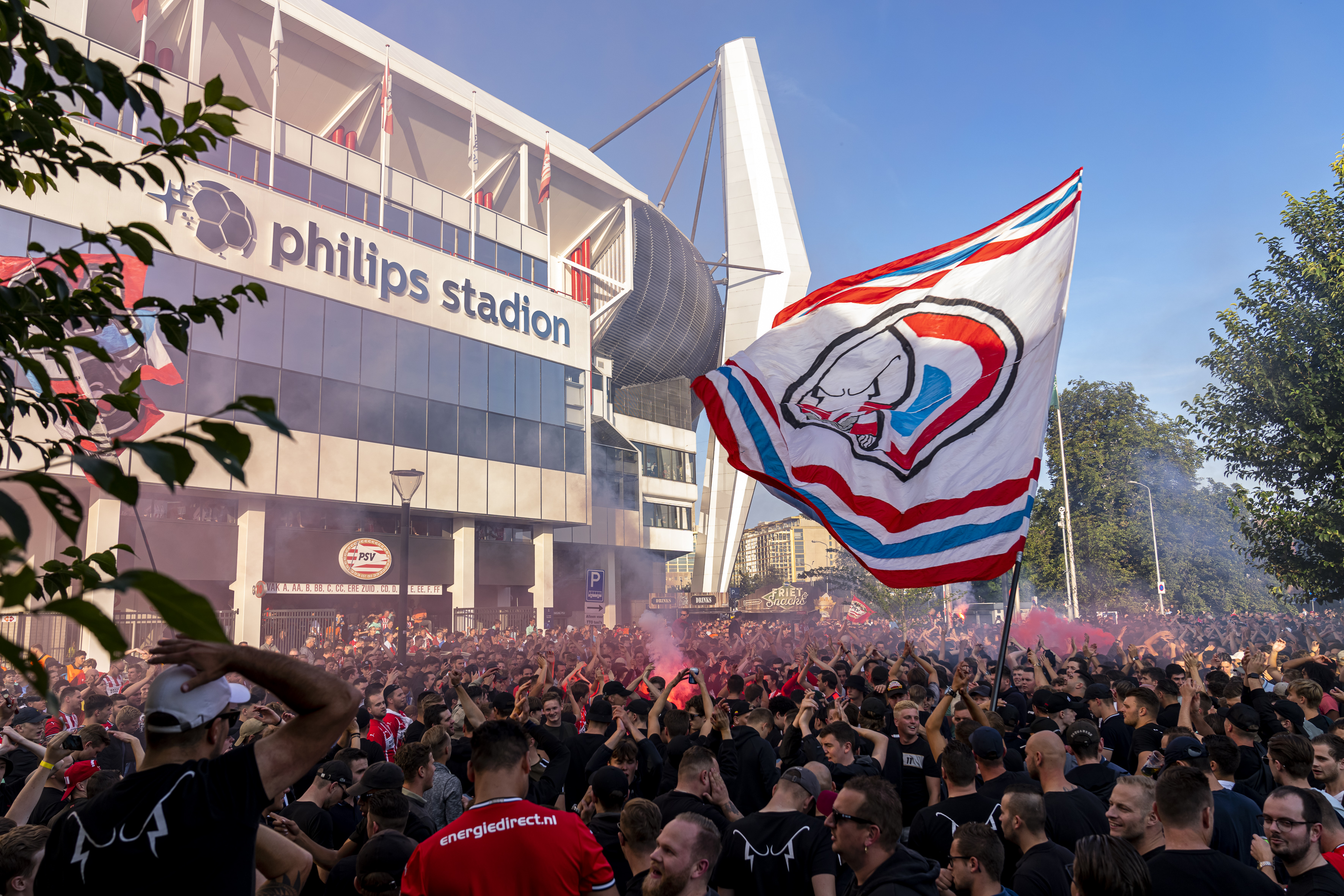 PSV-supporters met vlaggen buiten het Philips Stadion voor PSV-Benfica
