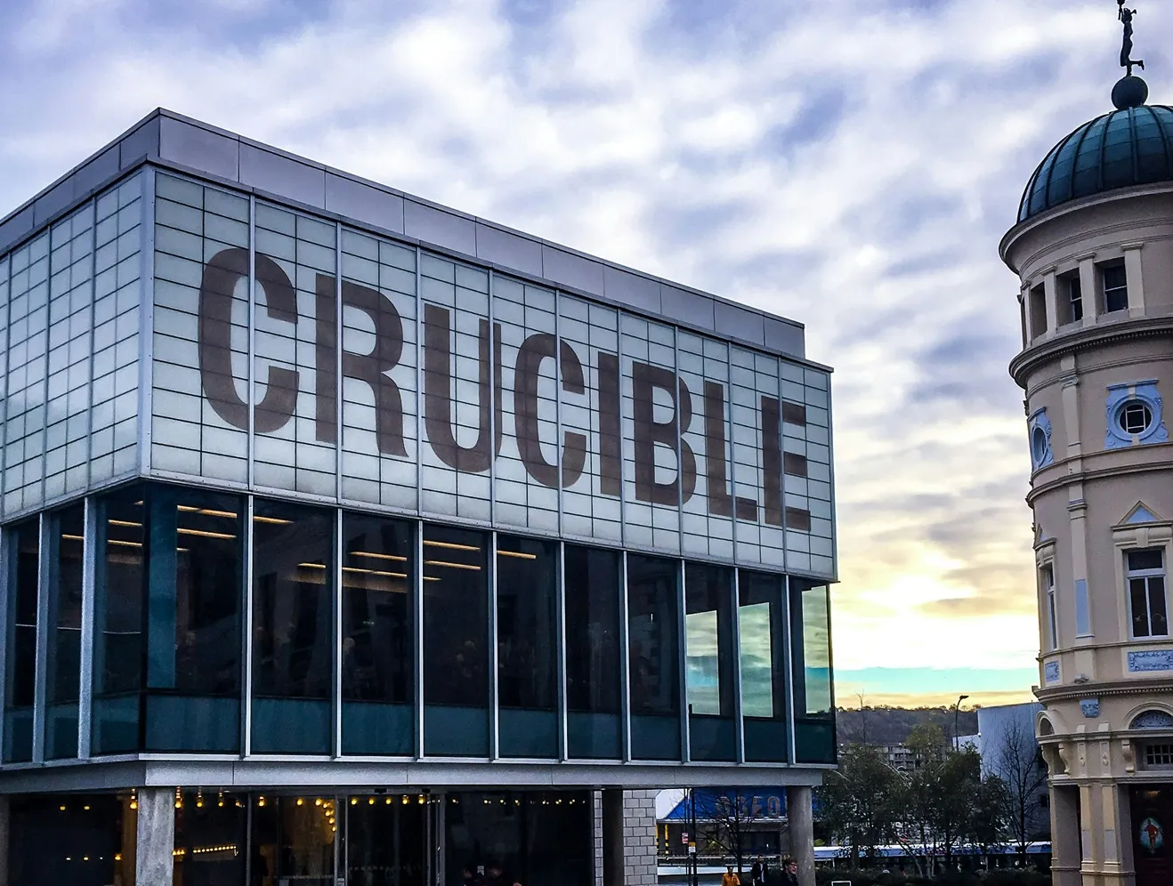 Gebouw met grote letters CRUCIBLE en een toren in de achtergrond