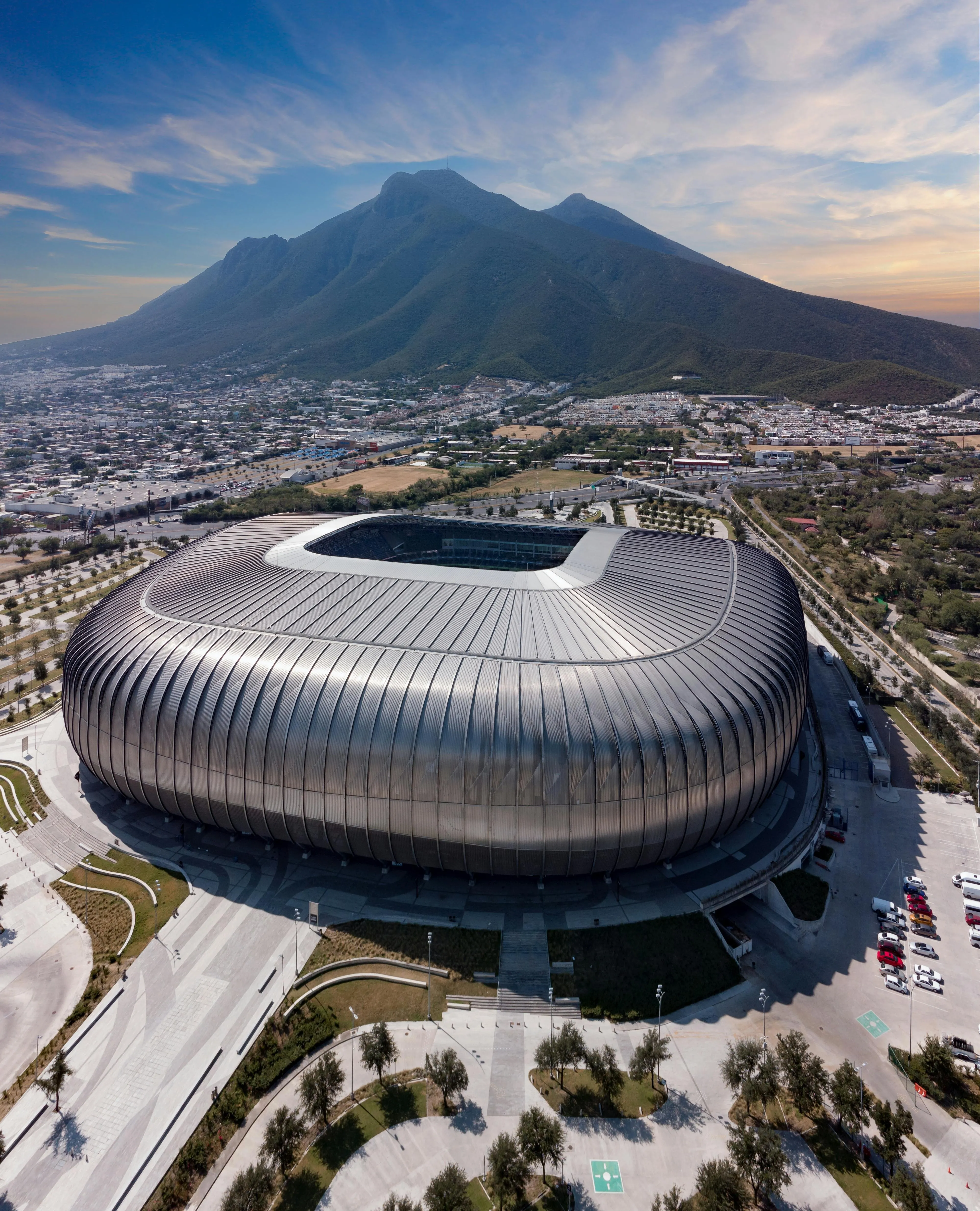 Luchtfoto van modern stadion bij bergen en stad
