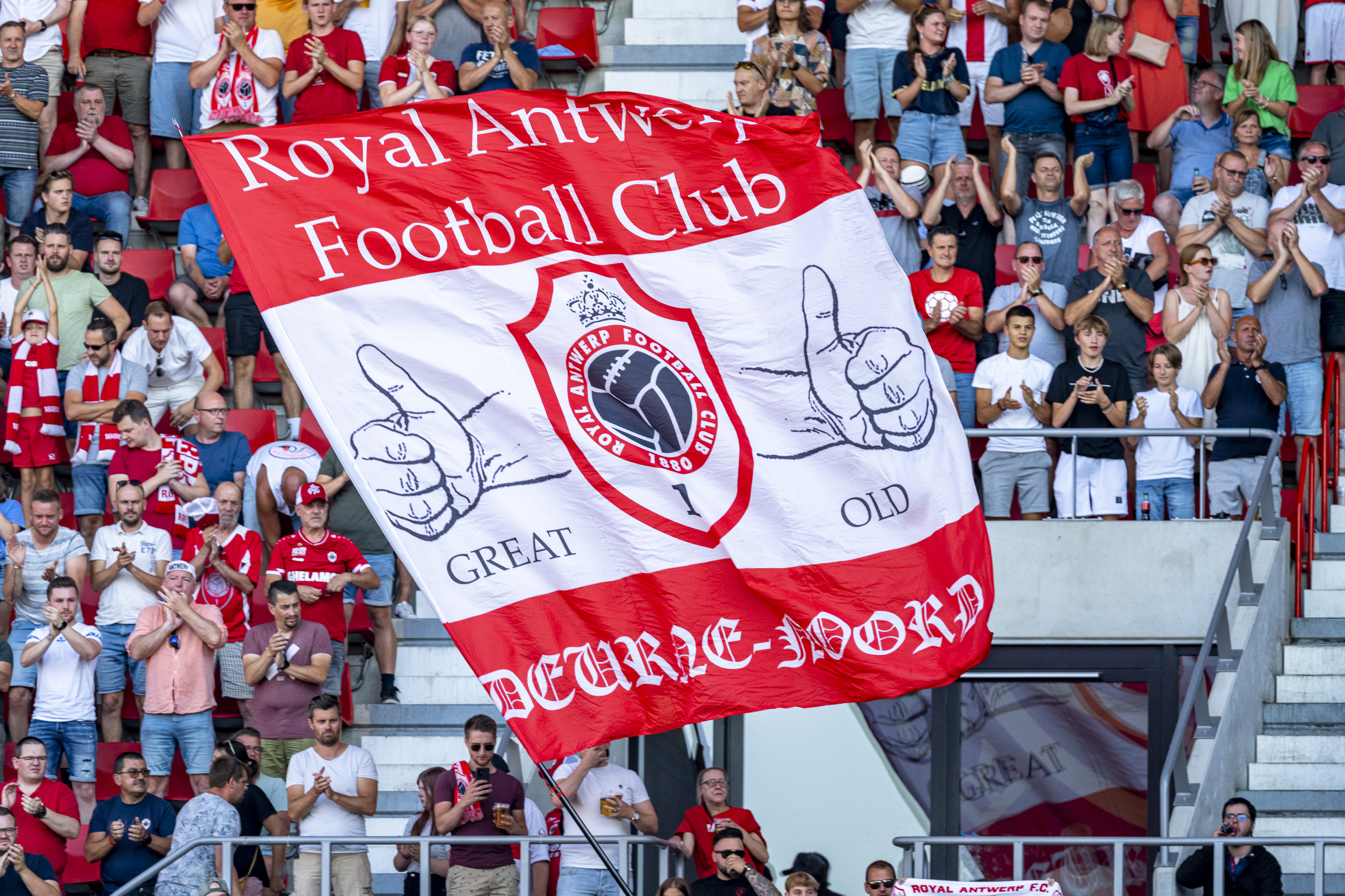 Supporters van Antwerp FC met de vlag van hun club in stadion De Bosuil