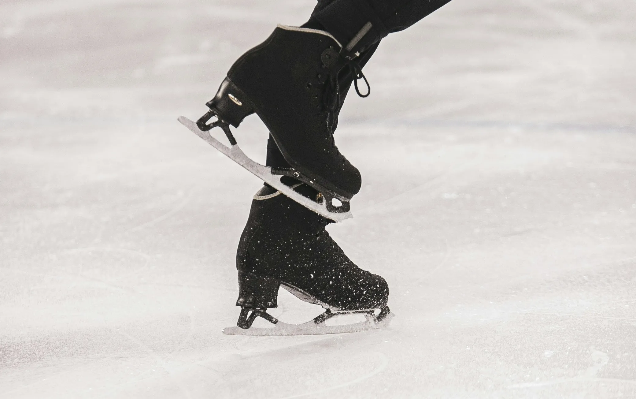Zwarte schaatsen op ijsoppervlak tijdens schaatsbeweging