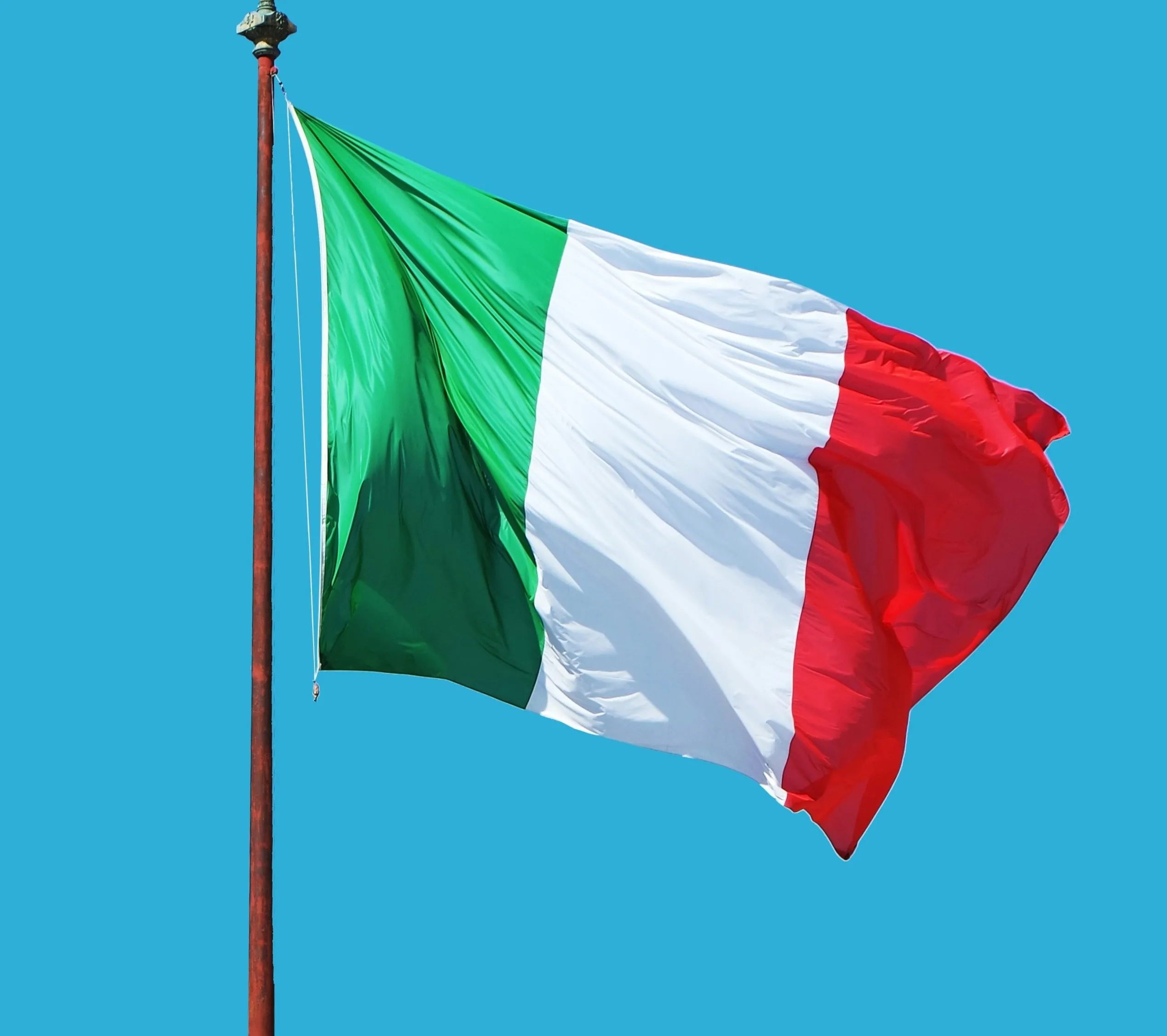 Vlag van Italië op een vlaggenstok tegen blauwe lucht