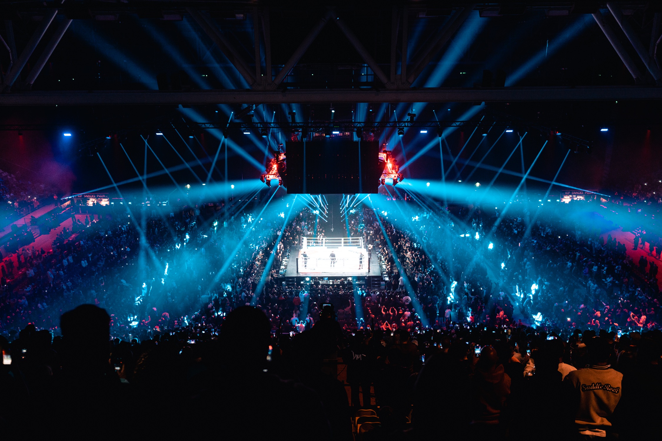 Een verlichte arena met in het midden een ring voor GLORY-gevechten