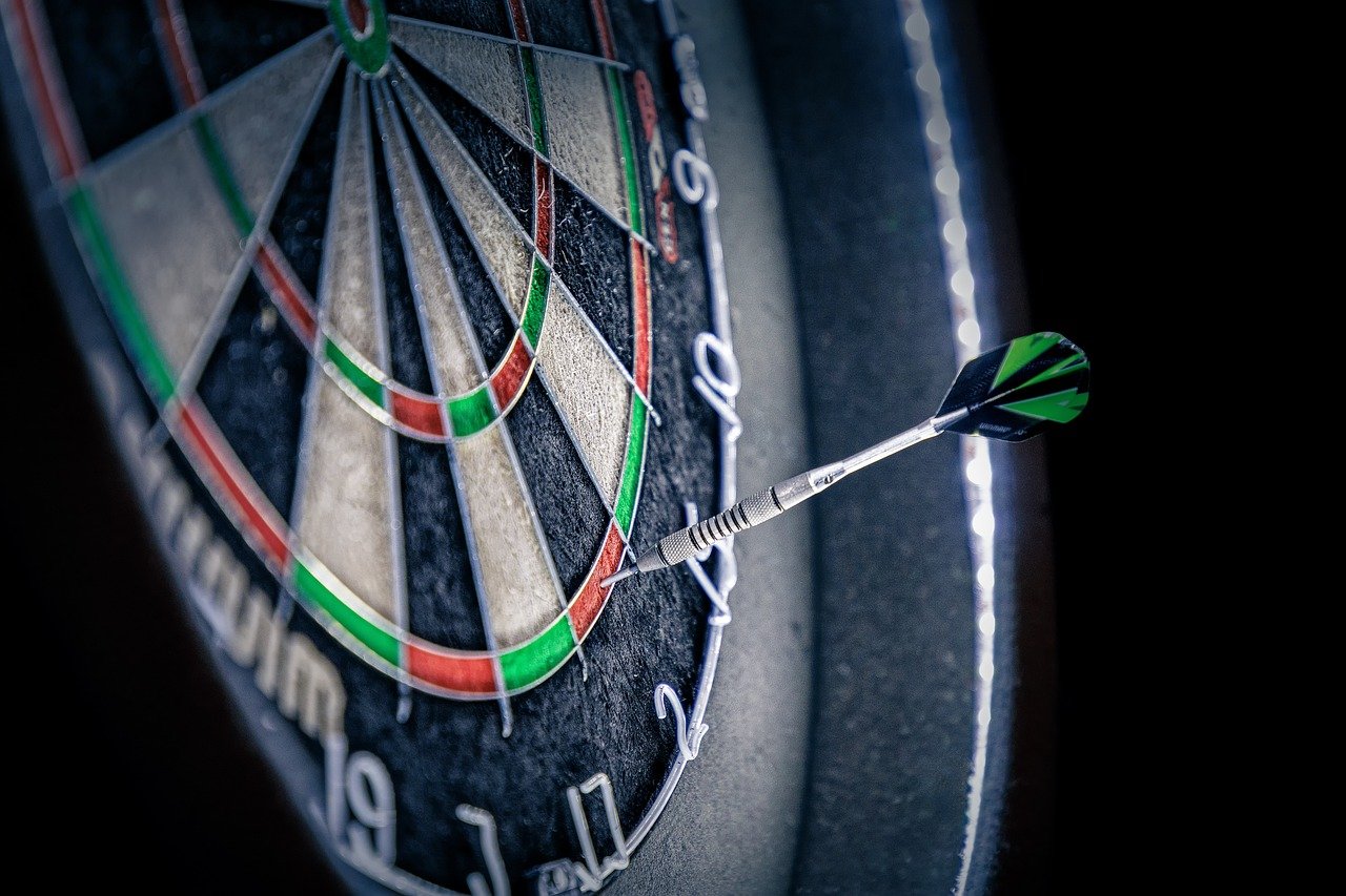Een close-up van een dartbord met een dartpijl die die het spel eindigt met een double out op het getal 2