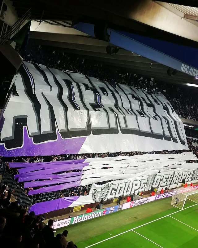 Grote sfeeractie met spandoek en paarse doeken bij een avondwedstrijd van RSC Anderlecht in Lotto Park