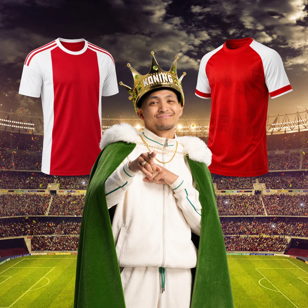 Man met koningskroon en cape op voetbalstadion met twee rood-witte voetbalshirts